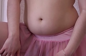 A girl in a pink skirt and in stockings masturbates her pussy